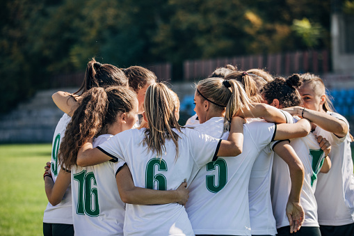 Group of women, women soccer team celebrating victory on soccer field.